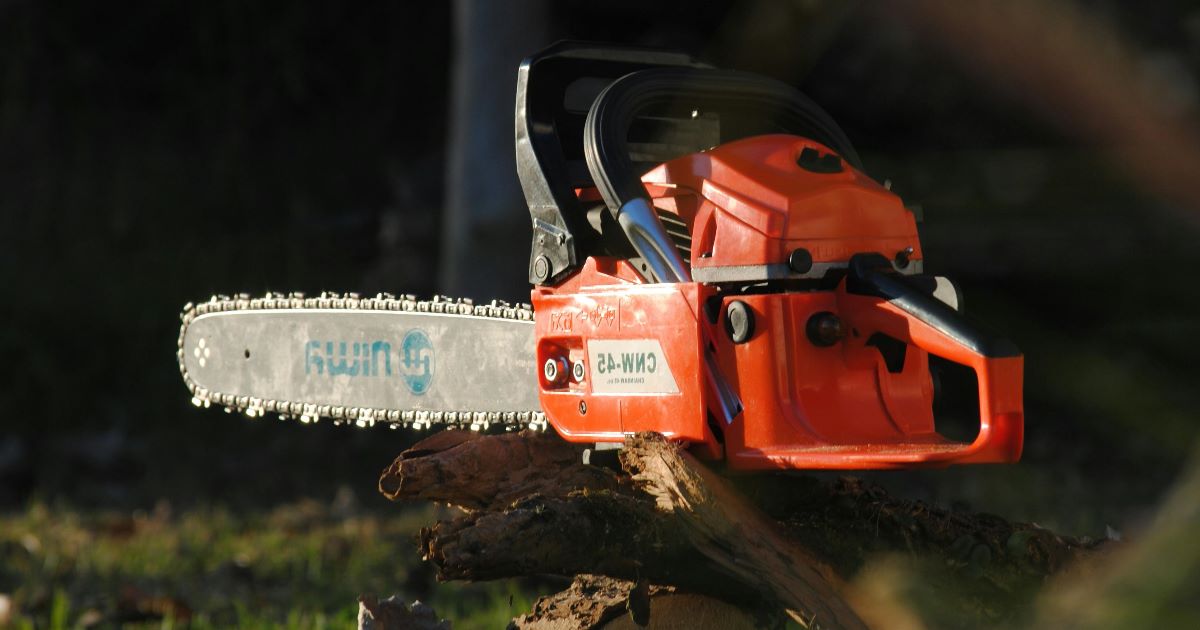 yhden käden moottorisaha puun päällä